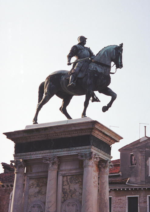 side view of a sculpture of a man on a horse on a high pedestal