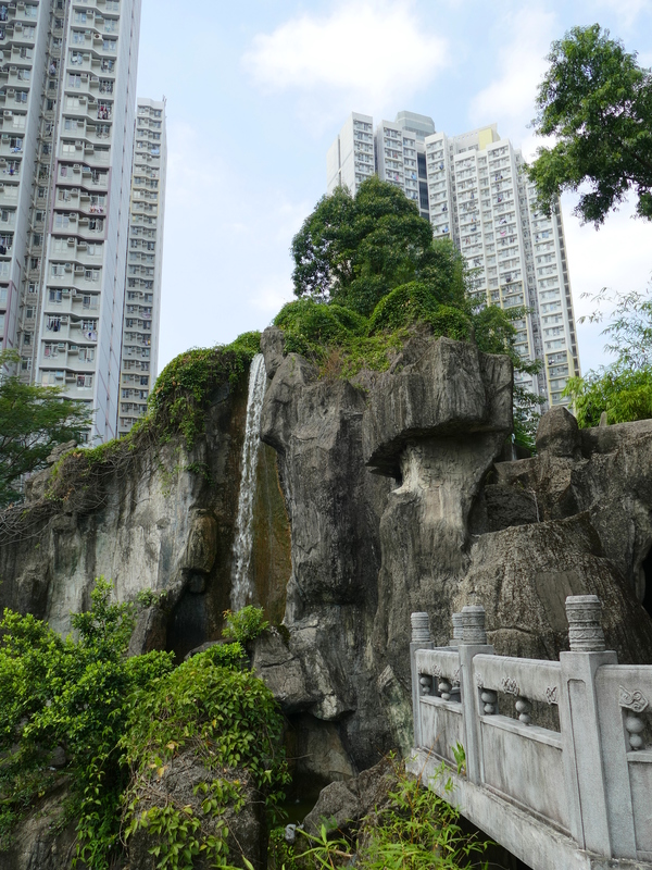 A lovely waterfall against a backdrop of apartment blocks