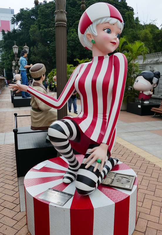 Life-size sculpture of a colourfully dressed female comic character