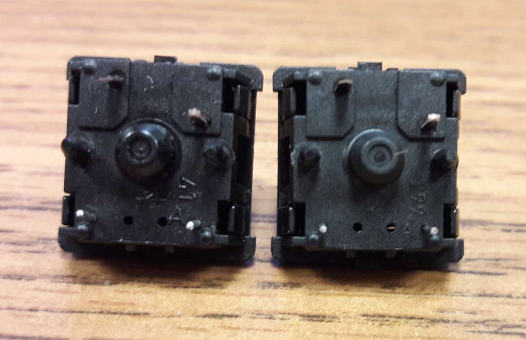 The undersides of two Cherry key switches