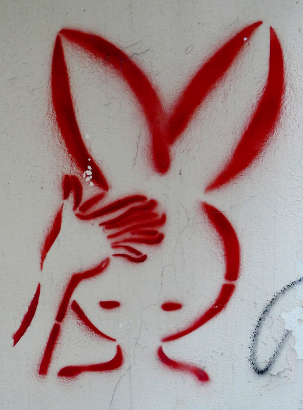 Graffiti image of a man(?) with huge rabbit ears and his hand to his forehead