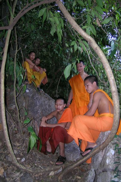 Monks waiting outside a cave entrance.