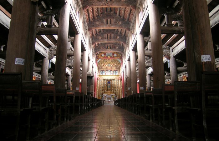 A view down the centre aisle of Phat Diem with massive wood beams supporting the roof