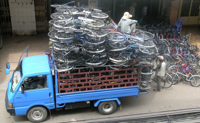 Truck stacked high with bicycles - with a guy sitting on the stack
