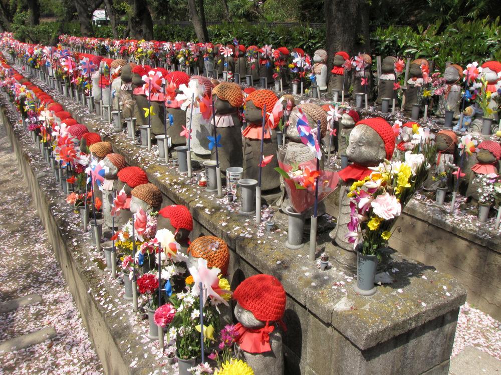 rows of dressed-up miniature stone Buddhas