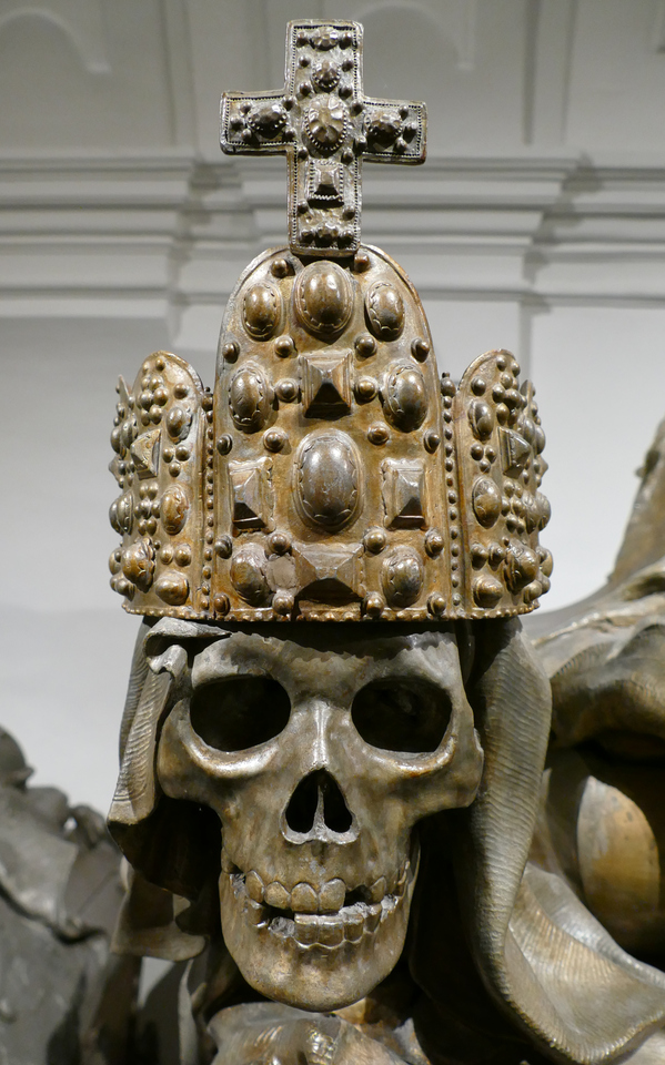a brass skull stares at you - it wears a large and ornate crown